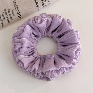 Close-up of purple organza scrunchie with pleated texture and pearl luster finish