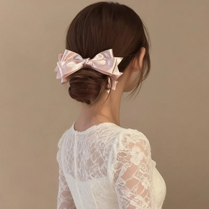 Elegante fermaglio per capelli con fiocco in raso rosa a pois su un'acconciatura raccolta