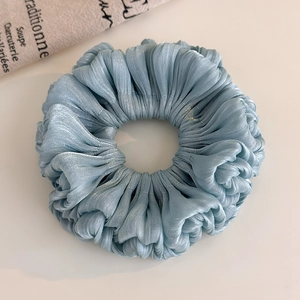 Detail of light blue pleated organza scrunchie with metallic luster and silky texture