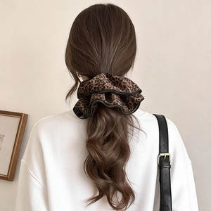 Velvet leopard print double-layered scrunchie for women tied on long brown wavy hair