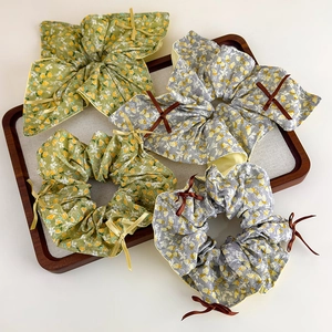 Florale Haargummis mit eleganten Bändern und kontrastreichen gelben Paspeldetails