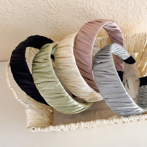Pleated satin wide headbands in five elegant colors displayed in a woven basket