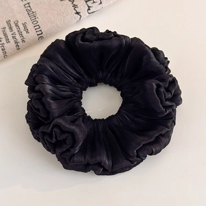 Close-up of black organza scrunchie featuring elegant pleated satin texture and high elasticity