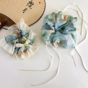 Floral watercolor scrunchie set with ribbons and pearl detail on white surface