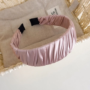 Detailed view of the pleated pink satin headband texture and soft fabric craftsmanship