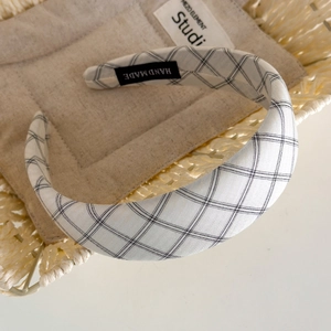 Close-up of handmade classic plaid headband with padded sponge and woven label
