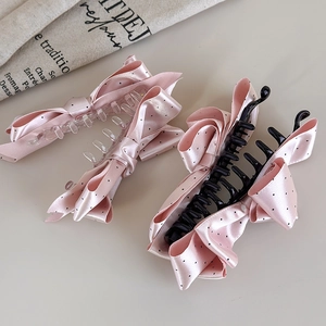 Dettaglio di fermagli per capelli con fiocco in raso rosa a pois stile coreano