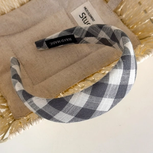 Detailed close-up of handmade black and white plaid headband with a soft fabric texture