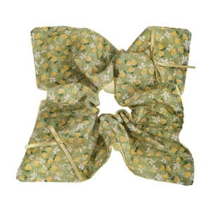 Detaillierte Makroansicht von großem Blumen-Scrunchie mit gelben Schleifen auf Stoff
