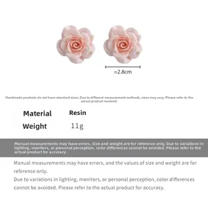 Détail de boucles d'oreilles rose avec fleur en résine de 2,8 cm et poids de 11g par pièce