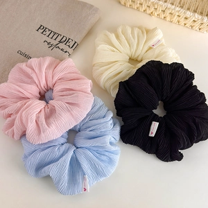 Close-up of pleated scrunchies set in four colors with cute Hand Made label accents