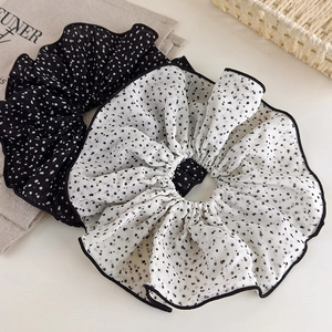 Détails de chouchous à pois noirs et blancs avec des bords élégants à volants