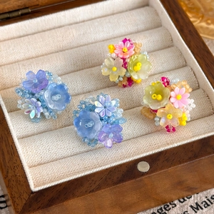 Détail de boucles d'oreilles hortensia faites main en perles de résine bleues, violettes et roses