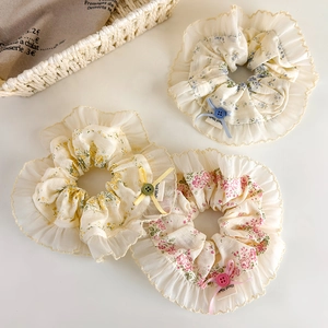Vue détaillée de chouchous floraux avec bordure en dentelle et nœud en ruban