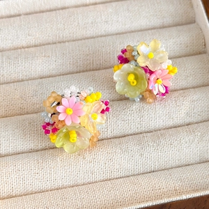 Vue macro de boucles d'oreilles fleuries perlées colorées dans un écrin à bijoux