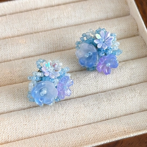Gros plan détaillé sur des boucles d'oreilles en perles faites main en forme d'hortensia
