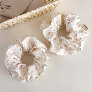 Close-up of floral scrunchies set with handmade tag and delicate pink flower patterns