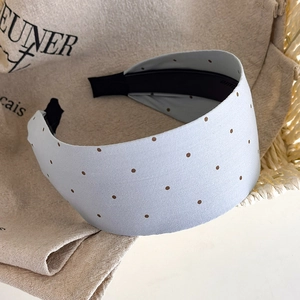 Detail of wide light blue polka dot headband with satin texture and anti-slip lining