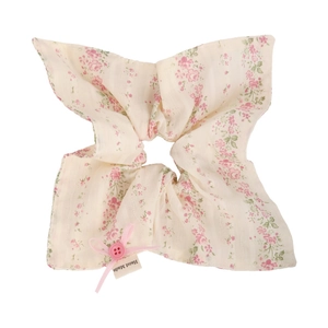 Vue détaillée du chouchou fleuri avec nœud rose, bouton et étiquette Hand Made