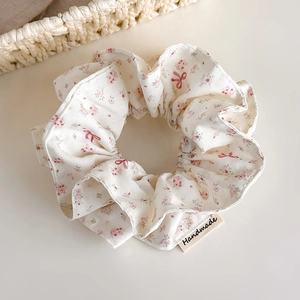 Close-up of floral scrunchie with handmade tag and pink butterfly patterns