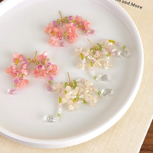 Detail von Perlenblumen-Ohrringen mit Wassertropfen-Anhängern in Pink und Creme-Weiß