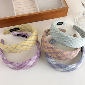 Detail view of handmade checkered headbands in five pastel colors with cloth labels