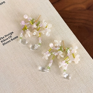 Detail von Perlenohrringen mit Blumenmuster und Kristall-Wassertropfen-Anhängern