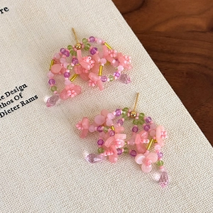Details von rosa geblümten Perlenohrringen mit Quasten aus Kristall-Wassertropfen