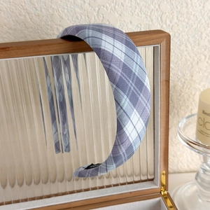 Detail of a thick padded plaid headband in purple and grey fabric for a retro look