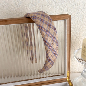 Retro cream plaid padded headband displayed on a vintage wooden storage box with glass