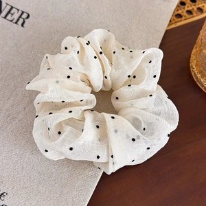 French style chiffon polka dot scrunchie in cream white on a rustic wooden table