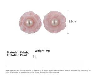 Detailed close-up of pink fabric flower earrings with center faux pearl accents