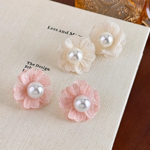 Romantic floral pearl stud earrings in pink and cream lace on a vintage textured book page
