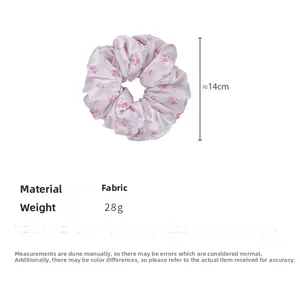 Dettaglio di un elastico per capelli in raso rosa a fiori da 14cm in morbido tessuto