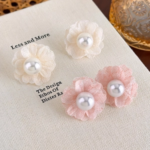 Detailed close-up of delicate chiffon flower earrings with pearls in cream and pink