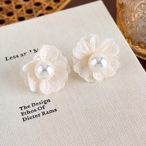 Close-up of cream chiffon fabric flower earrings with glossy white pearl center detail