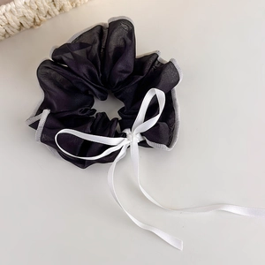 Detail of black organza scrunchie with grey edging and delicate white silk bow