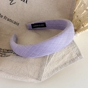 Detailansicht des Handmade-Etiketts auf einem violetten, gepolsterten Stoffstirnband