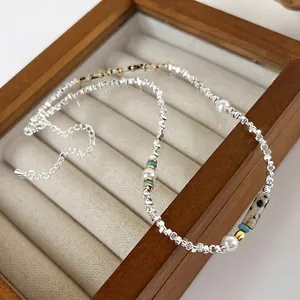 Collier vintage avec pierres vertes, perles et perles d'argent sur boîte à bijoux