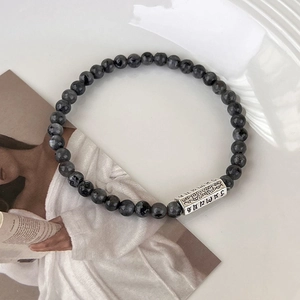 Gros plan détaillé du bracelet en perles de labradorite avec perle tibétaine gravée