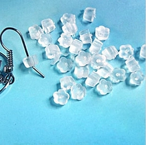 Translucent flower shaped silicone earring backs for jewelry making on blue backdrop