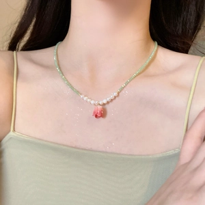 Collana con ciondolo a tulipano, perline verde chiaro e perle bianche indossata al collo