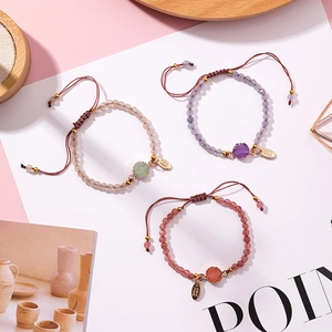 Detail of handmade adjustable woven bracelets with faceted natural stone beads and metal tags