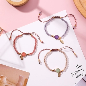 Detailed close-up of woven bead bracelets with natural stones and metal hand made tags