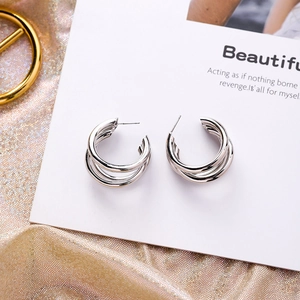 Silver multi-layer C-shaped hoop earrings with geometric tiered design and polished finish