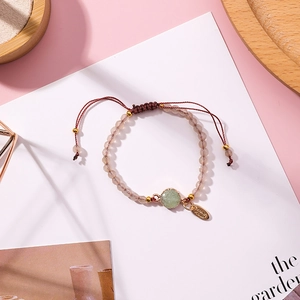 Minimalist hand-woven bead bracelet with green natural stone and adjustable tassel cord