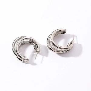 Macro detail of multi-layered silver geometric hoop earrings with polished metallic finish