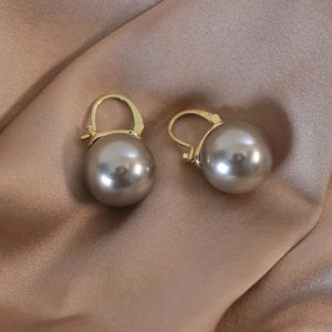 Elegant champagne pearl leverback earrings with golden metal hooks on silk fabric
