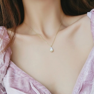 Elegant gold chain necklace with a sparkling teardrop zircon pendant on a model