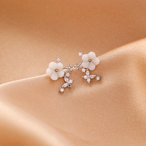 Elegant floral zircon earrings with white shell petals on a luxury gold satin background